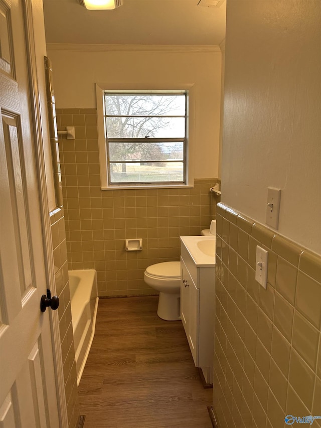 bathroom featuring vanity, tile walls, crown molding, and toilet