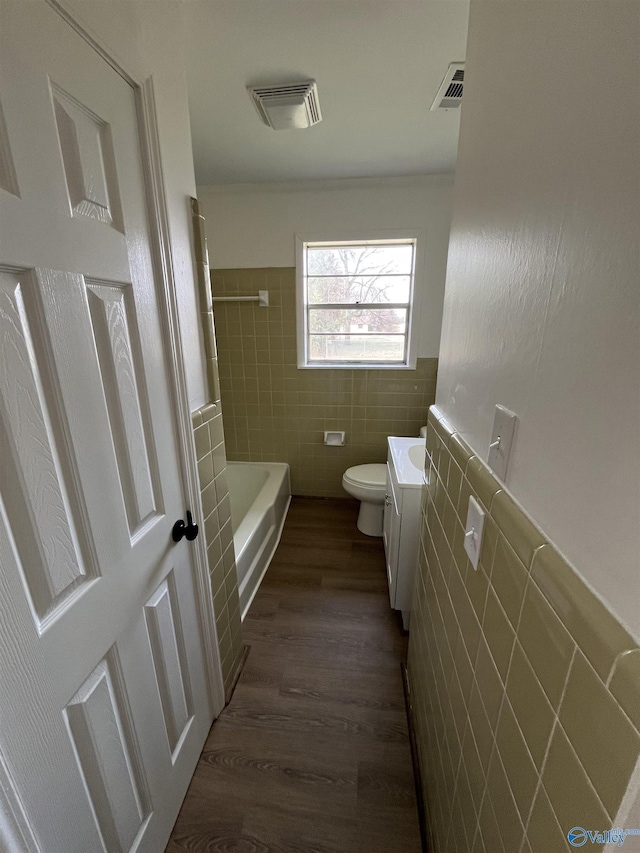 bathroom with vanity, hardwood / wood-style floors, tile walls, and toilet