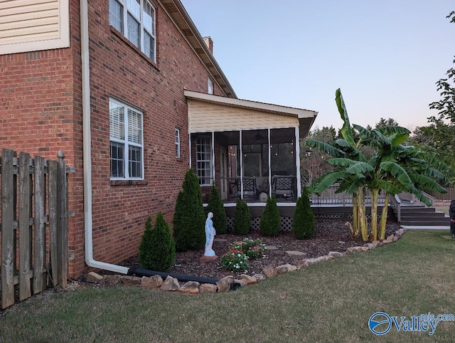 view of property exterior with a sunroom and a yard