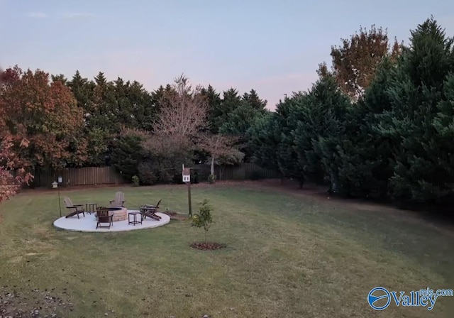 yard at dusk with a patio and an outdoor fire pit