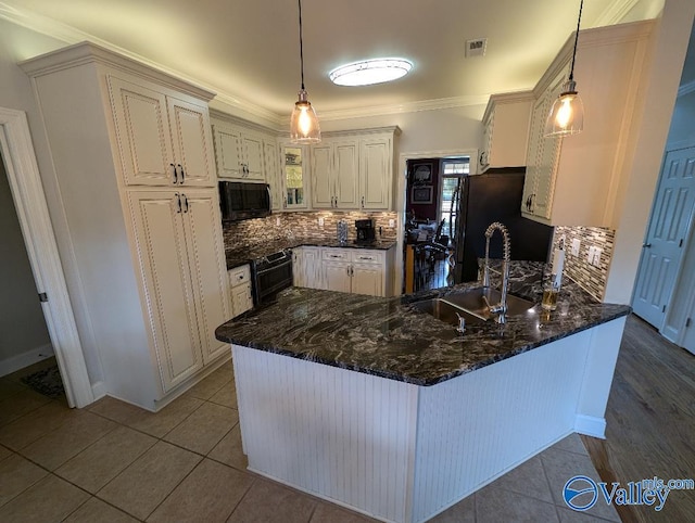 kitchen with kitchen peninsula, light tile patterned floors, decorative light fixtures, and tasteful backsplash