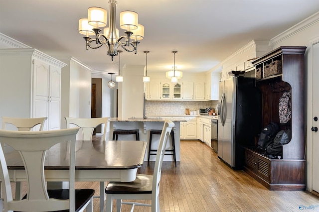dining area with a chandelier, a toaster, ornamental molding, and hardwood / wood-style flooring