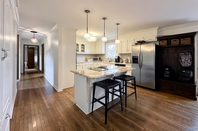 kitchen with stainless steel fridge with ice dispenser, glass insert cabinets, a center island, ornamental molding, and dark wood-style floors