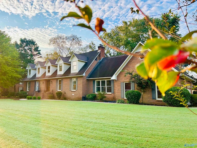 cape cod home featuring a front lawn