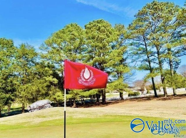 view of property's community with view of golf course and a yard
