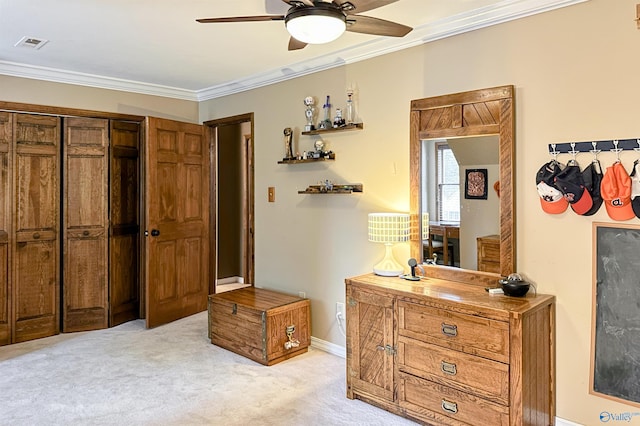 bedroom with a ceiling fan, ornamental molding, visible vents, light carpet, and baseboards