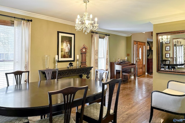 dining space with an inviting chandelier, crown molding, and wood finished floors