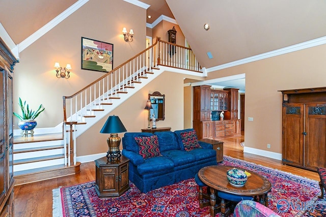 living room with baseboards, stairs, wood finished floors, and crown molding