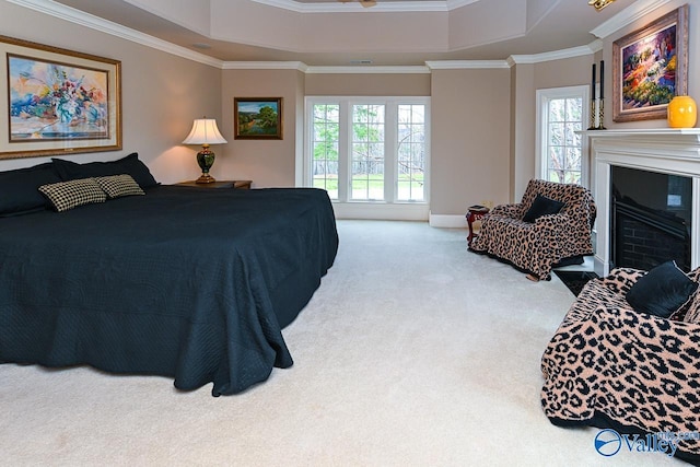 bedroom featuring a tray ceiling, crown molding, multiple windows, and carpet