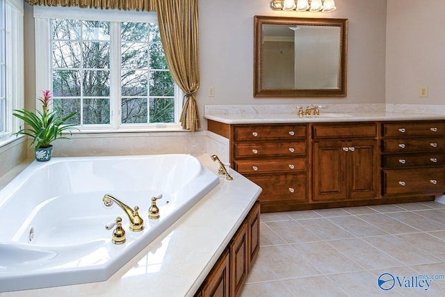 bathroom with a tub with jets, tile patterned flooring, and vanity