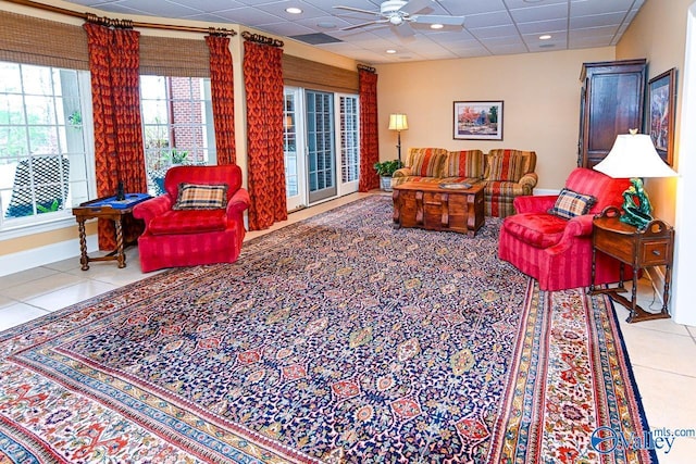 tiled living area featuring baseboards, a drop ceiling, recessed lighting, and a ceiling fan