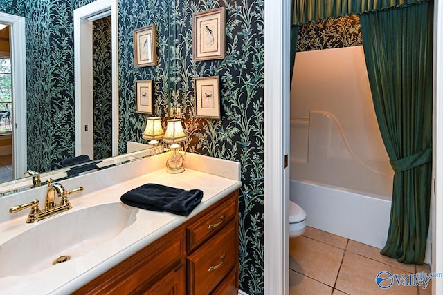 bathroom featuring toilet, vanity, washtub / shower combination, tile patterned flooring, and wallpapered walls