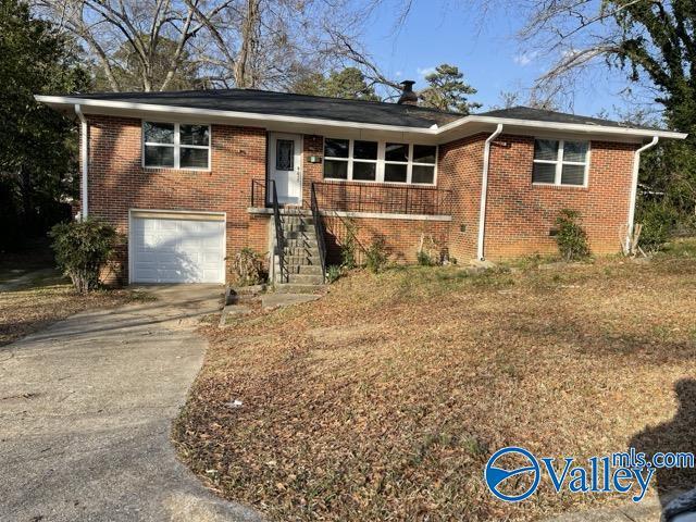 ranch-style house with a garage, brick siding, and driveway