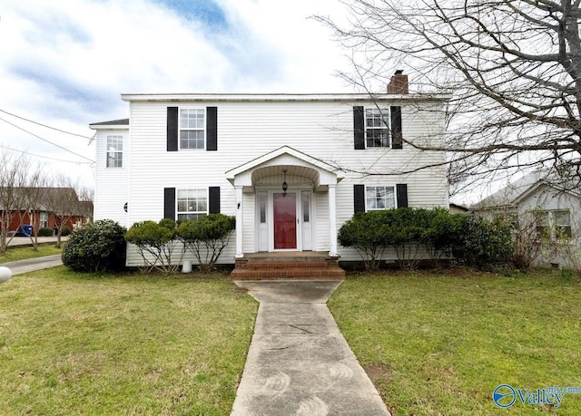 view of front of home featuring a chimney and a front yard