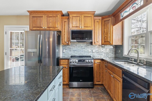 kitchen featuring a sink, stainless steel appliances, brown cabinets, and tasteful backsplash