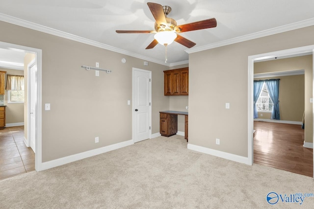 interior space featuring baseboards, light carpet, and ornamental molding