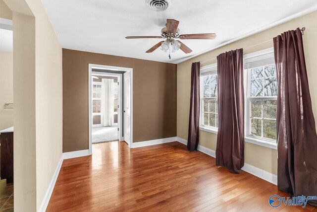 empty room with visible vents, a healthy amount of sunlight, and light wood-style floors