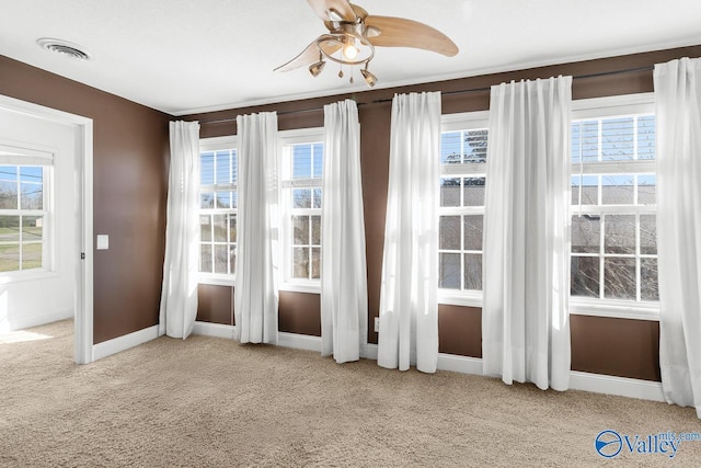 doorway featuring a wealth of natural light, visible vents, a ceiling fan, and carpet floors