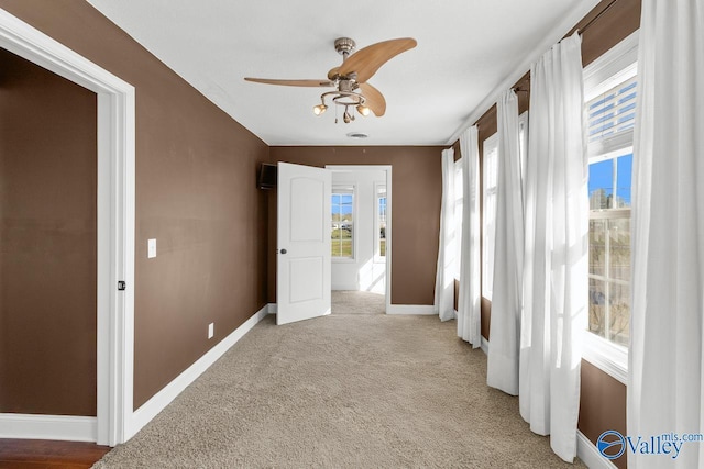 interior space with baseboards and light colored carpet
