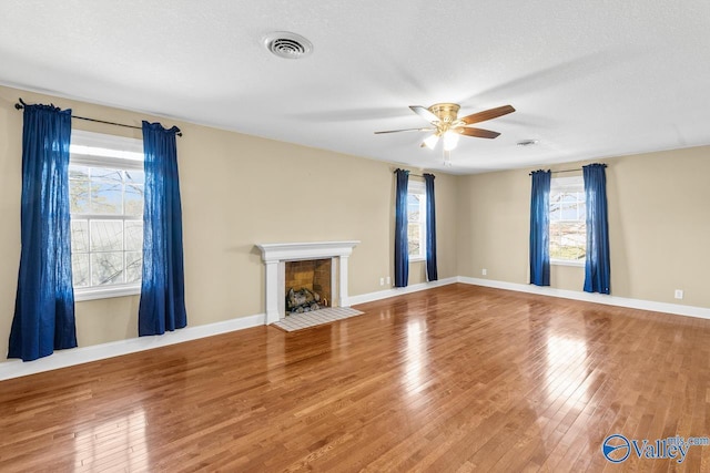 unfurnished living room featuring visible vents, ceiling fan, and hardwood / wood-style floors