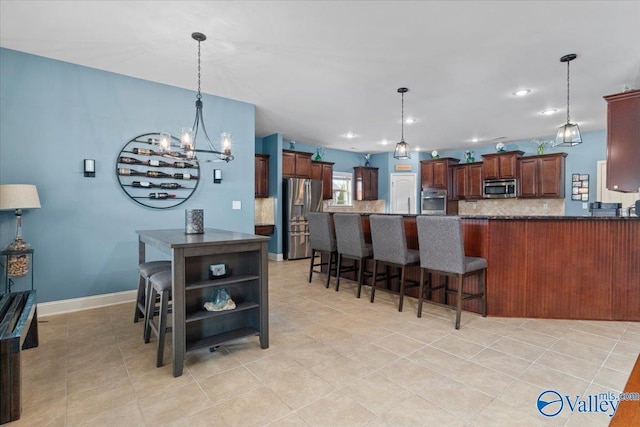 kitchen featuring stainless steel appliances, a kitchen bar, and hanging light fixtures