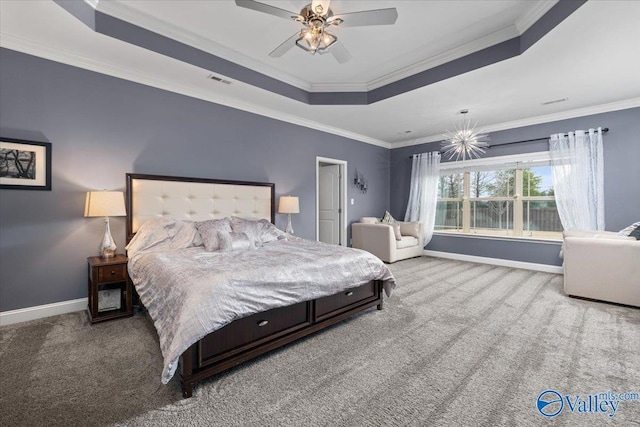 bedroom featuring ceiling fan, ornamental molding, a tray ceiling, and carpet flooring