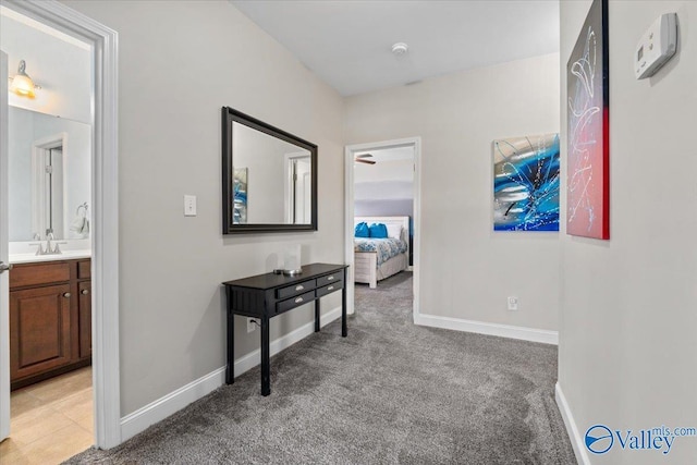 corridor with sink and light carpet