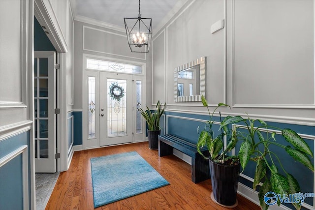 entrance foyer featuring a notable chandelier, light hardwood / wood-style flooring, and ornamental molding