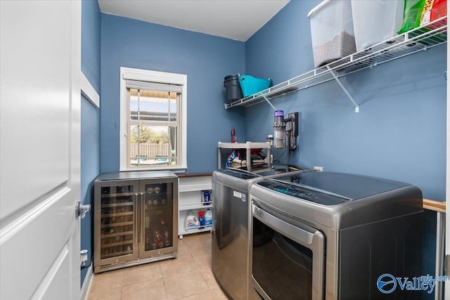 laundry area featuring beverage cooler, washing machine and clothes dryer, and light tile patterned flooring