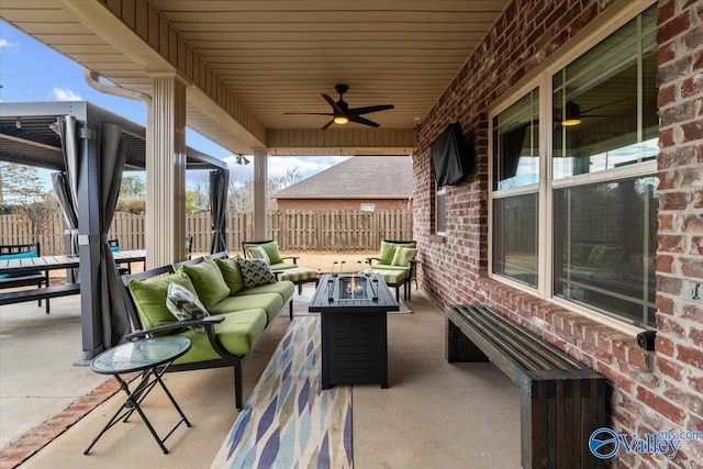 view of patio / terrace with ceiling fan and an outdoor living space with a fire pit