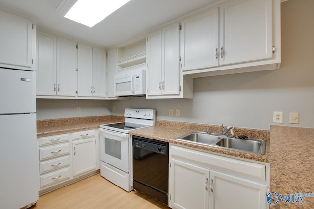 kitchen featuring sink, white cabinets, light wood-type flooring, and white appliances