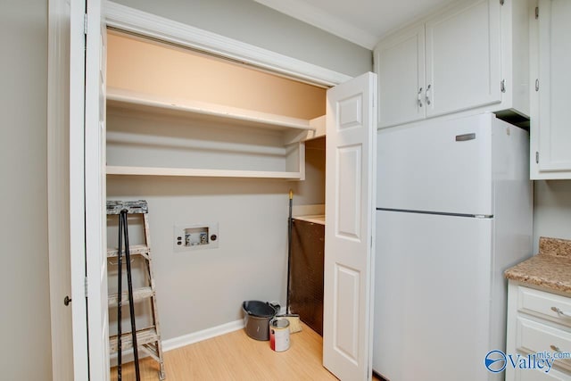 clothes washing area featuring washer hookup, baseboards, wood finished floors, and laundry area