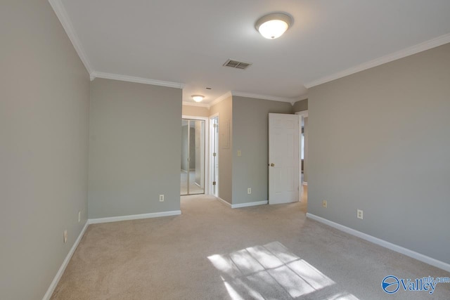 empty room with ornamental molding and light carpet