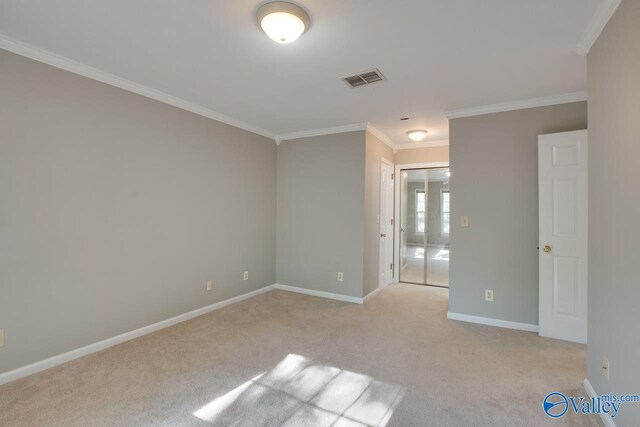 carpeted spare room featuring crown molding