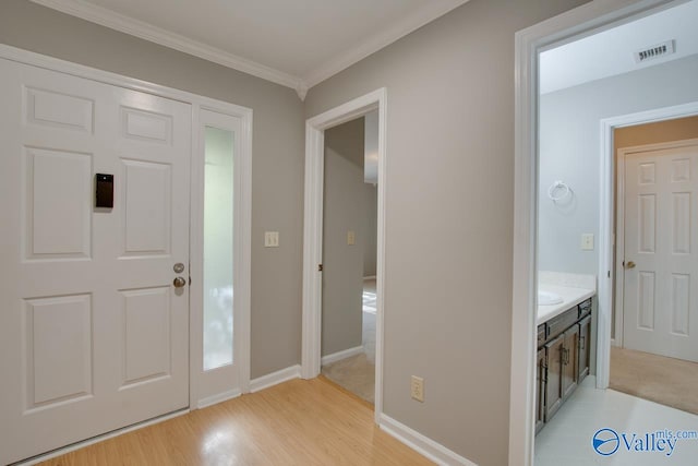 foyer entrance featuring light hardwood / wood-style floors and ornamental molding