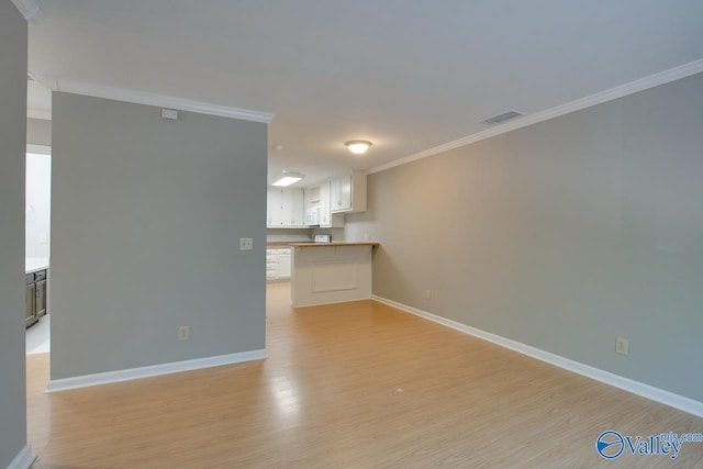 unfurnished living room featuring ornamental molding and light hardwood / wood-style flooring