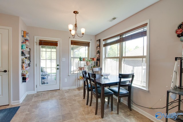 dining room featuring visible vents, baseboards, a wealth of natural light, and a notable chandelier