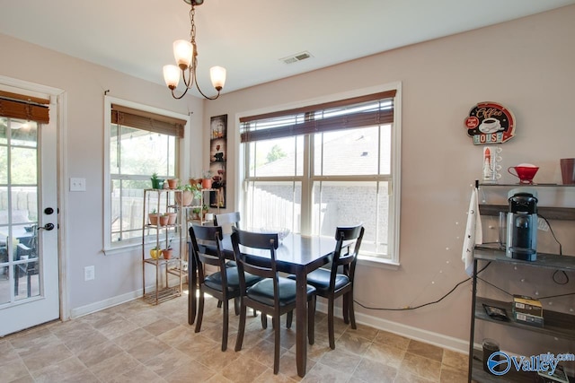 dining area with an inviting chandelier, visible vents, and baseboards