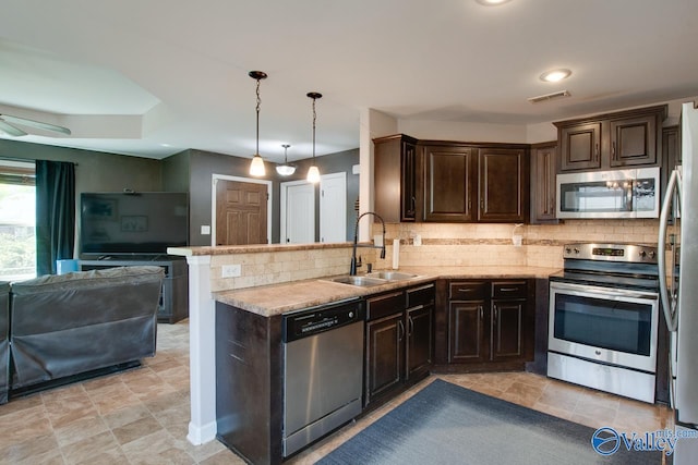 kitchen with backsplash, dark brown cabinets, a sink, appliances with stainless steel finishes, and open floor plan