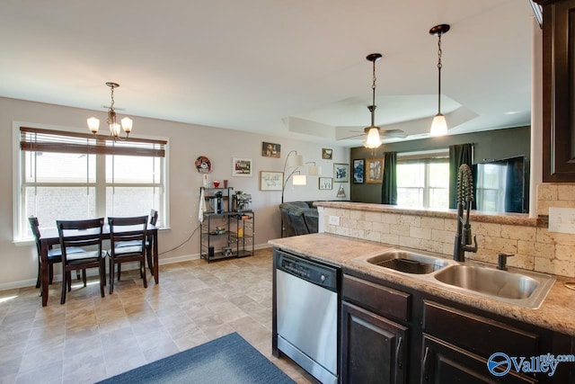 kitchen featuring a tray ceiling, a sink, baseboards, backsplash, and dishwasher