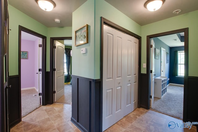 hallway with light carpet and baseboards