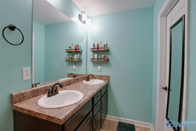 bathroom featuring double vanity, baseboards, and a sink