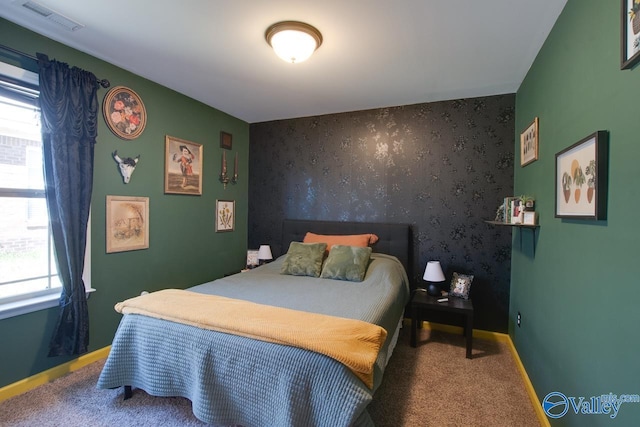 carpeted bedroom with baseboards, visible vents, an accent wall, and wallpapered walls