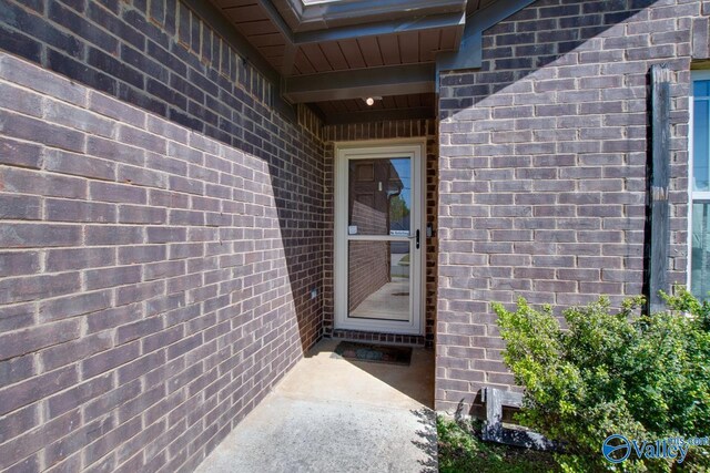 doorway to property with brick siding