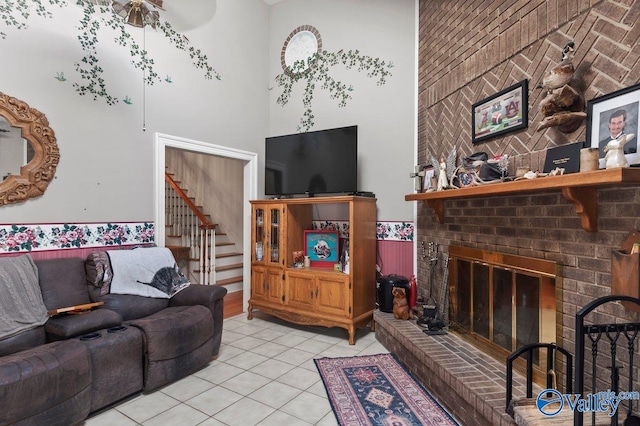 tiled living room featuring a towering ceiling and a fireplace