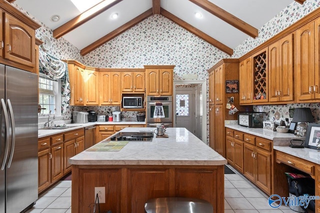 kitchen with light countertops, appliances with stainless steel finishes, vaulted ceiling with beams, and a sink