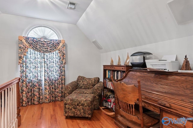 sitting room with visible vents, wood finished floors, and lofted ceiling