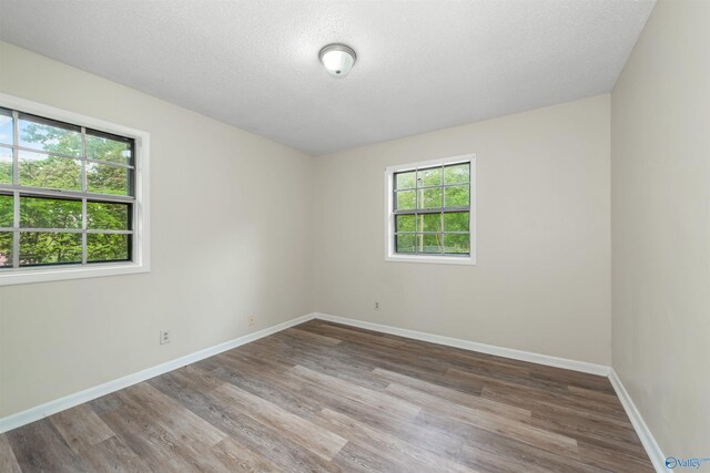 unfurnished room featuring a textured ceiling and hardwood / wood-style floors