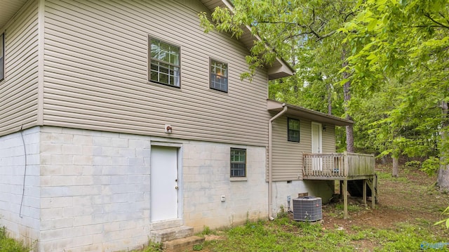 rear view of property featuring a wooden deck and cooling unit