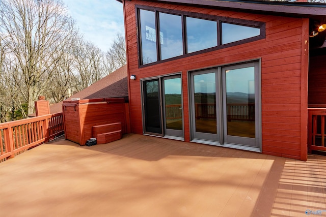 exterior space with a shingled roof and a wooden deck